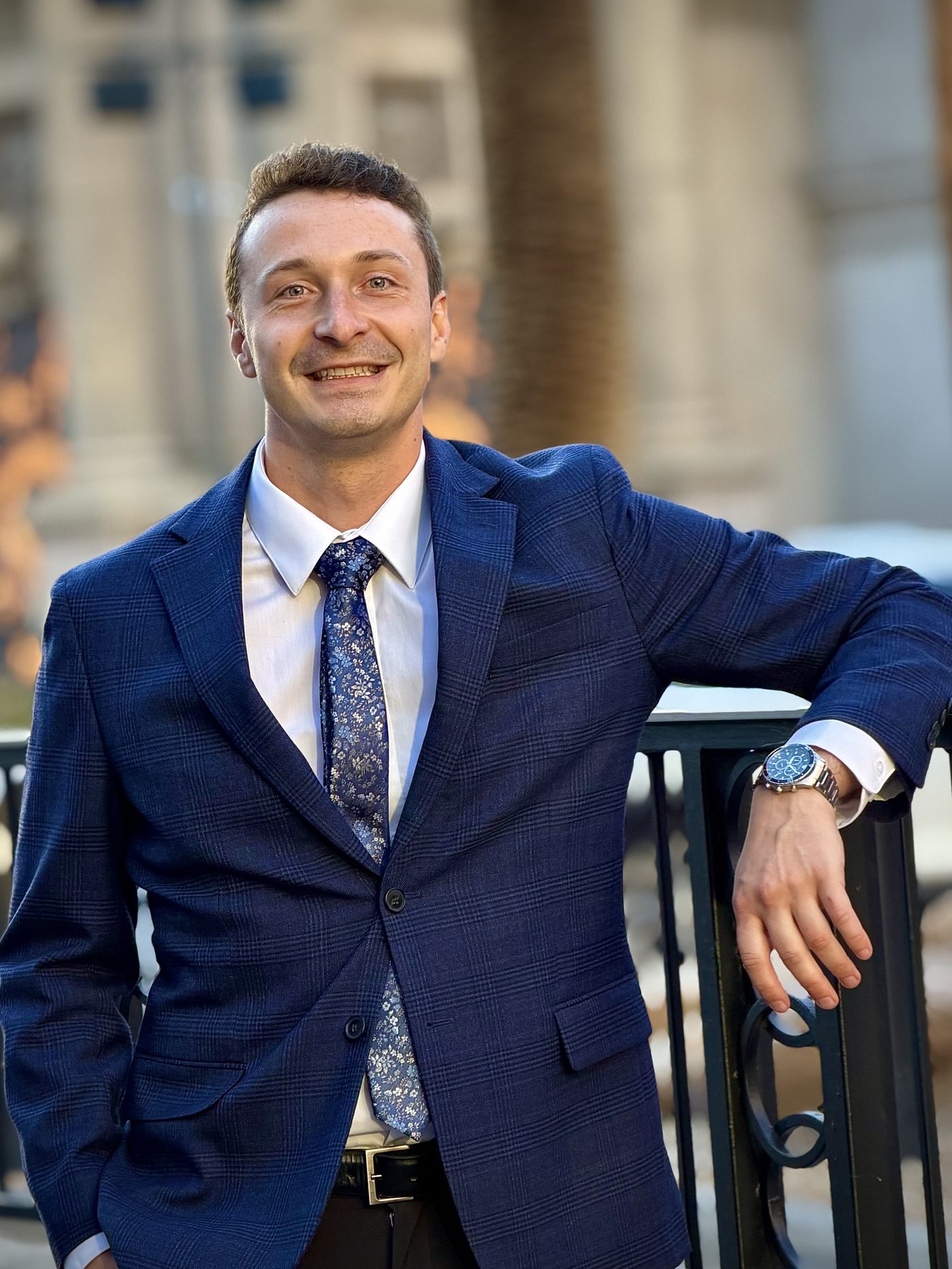 Caleb Bullard in a navy suit, photographed outdoors in Scottsdale, Arizona.