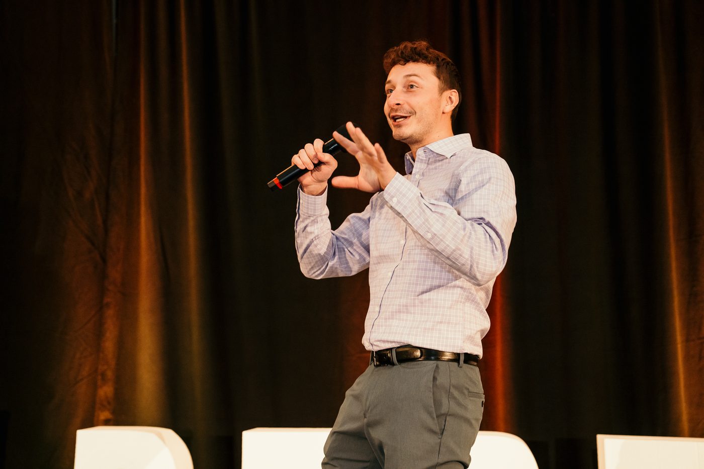 Caleb Bullard speaking on stage with a microphone.